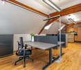 office room with wooden floor, wooden beams, office desk, office chair, flower vase, office partition