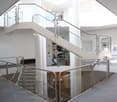 modern building, glass railings, white walls, gray floor, central staircase