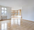 spacious room, wooden parquet floor, large bay windows, white walls, radiator, view