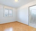 empty room, wooden floor, white walls, window with blinds, power outlets, open door to stairs