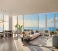 modern living room with large windows, wooden floor, white couch, dining table, chandelier, ocean view