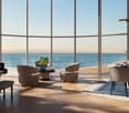 modern living room with a grand piano, round table, chairs, and a dining table with flowers