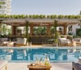Outdoor bar with a pool, lounge chairs, tables, plants, and a view of the city