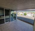 Balcony with sliding glass doors, tiled floor, couch, view of the city