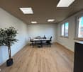 empty room, wooden floor, white walls, two desks, two chairs, potted plant, two windows