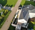 Modern house, gray roof, swimming pool, 3 cars parked, green lawn, garden, aerial view