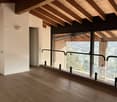 large windows, wooden floor, white walls, wooden ceiling, balcony with railings