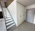 white tiled floor, white walls, metal staircase, white cabinets, white door