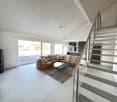modern living room, white tiles, large windows, glass doors to balcony, sectional sofa, coffee table, fireplace