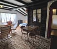 small room with a dining table and chairs, couch, a single bed, a wardrobe, windows, a fireplace, and a radiator