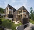 Two-story modern house with a unique angular design, featuring large windows and wooden accents. The house is situated on a grassy hill surrounded by trees. There is a garage visible on the ground level.
