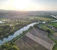 Aerial view of a river with surrounding farmland and distant village