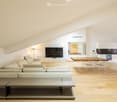 loft style living area, large sofa, TV, dining table, wooden floors