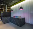 Reception area with black marble desk, white curtain, and hanging lamps