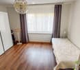 small bedroom, wooden floor, large white wardrobe, single bed, clothes hanger, window with curtains, ceiling lamp