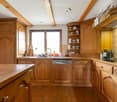wooden cabinets, countertop, sink, dishwasher, gas stove, tile flooring