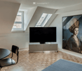 flat with wooden floor, tv, artwork, armchair