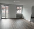 empty room, wooden floor, white walls, sliding doors, balcony, radiator