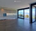 Open plan kitchen with modern appliances, wooden balcony, sliding doors with panoramic views