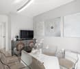 modern, open concept, glass table, white chairs, white tiled floor, artwork on the wall, television, sideboard