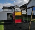 A playground with a climbing frame and swings in the middle of the grass.