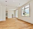 Empty room, wooden floor, glass windows, white walls, wooden door, radiator