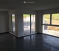 Empty room with sliding glass doors leading to balcony, tiled flooring, power outlets, windows