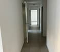 Empty hallway, tiled flooring, white walls, ceiling lights
