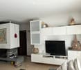 white walls, fireplace, flat screen TV, white cabinets, decorative items