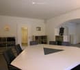 Conference room with a large triangular table and shelves with books