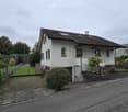 Detached house, two floors, brown roof, white exterior, visible windows, garage