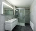 Double sink, shower enclosure, large mirror, tiled flooring