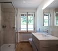 walk-in shower, bathtub, toilet, sink, radiator, windows, tiled floor, wooden floor