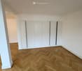 empty room, wooden parquet floor, large built-in wardrobes, white walls