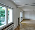 large windows, balcony, wooden floor, white walls, radiators