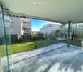 Glass walls, tiled floor, view of a grassy lawn and building