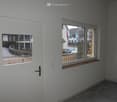 Empty room, door, windows, white walls, gray floor