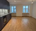 kitchen, dark wooden cabinets, sink, gas stove, dishwasher, wooden floor, radiators, two large windows