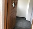 room with a wooden door and tiled floor