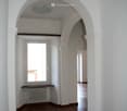 Hallway with arched windows, radiator, arched ceiling, wooden floor