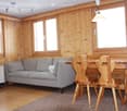 3 windows, sofa, wooden table, wooden chairs, floor heating