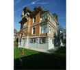 2 story house, brick and white paint, balcony, arch windows, lamp, tree, walkway