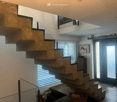Modern staircase with glass railing, wooden floor, white walls, sliding door, window with blinds