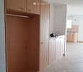 Large built-in wardrobe, cabinets, counter with electric outlets, and dishwasher.