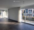 empty room with sliding glass doors leading to a balcony, tiled floor, large windows