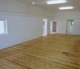 large room, white walls, wood floor, open doors
