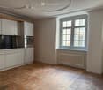 white cabinetry, brick floor, stainless steel oven, window with natural light, wall radiator, clean and empty space