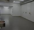 empty room, white walls, gray floor, fluorescent lights, stainless steel sink, stainless steel faucet, ventilation unit