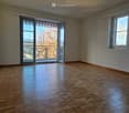 empty room, hardwood floor, double doors leading to balcony, windows