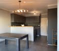 large open kitchen, modern appliances, dining table, light fixtures, cabinets